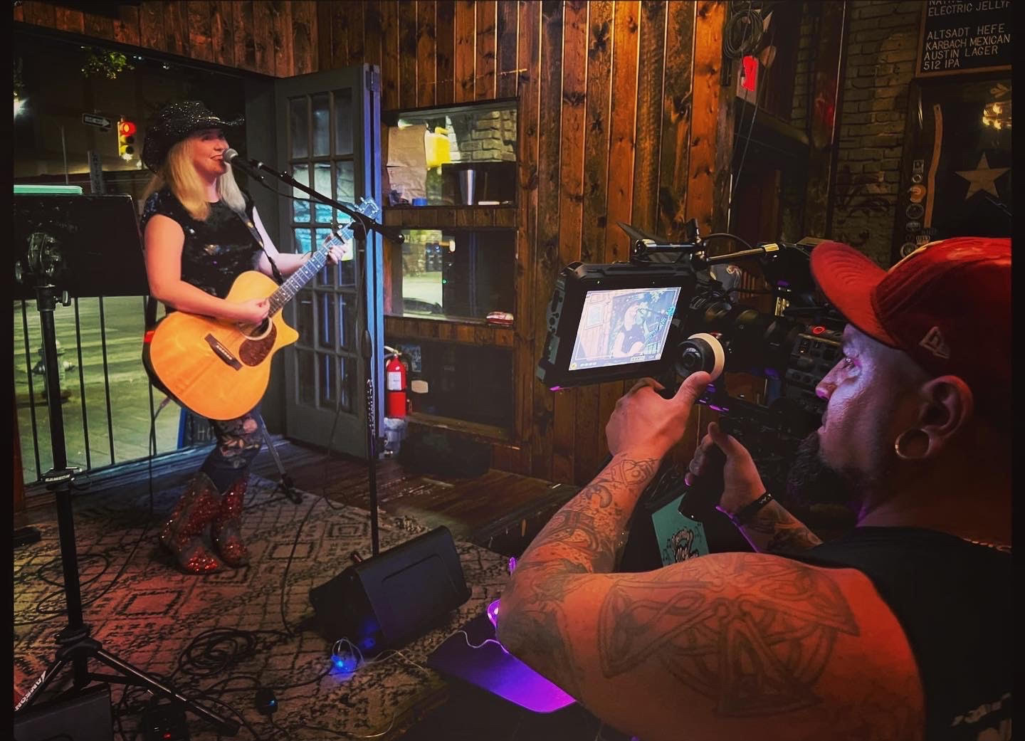 Meg Groves performing in front of a crowd. This photo is a Behind The Scenes look at her new music video, "Thank You Letter."